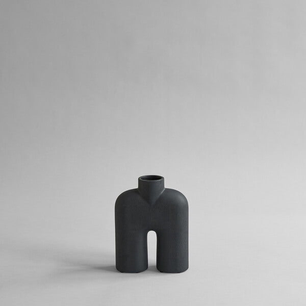 Tall black two-legged ceramic vase for holding flowers