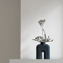 Load image into Gallery viewer, Tall black two-legged ceramic vase for holding flowers
