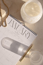 Load image into Gallery viewer, Sustainable white glass candle lamp styled with calendar
